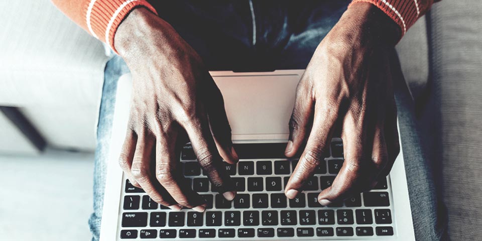 man's hands typing on a keyboard